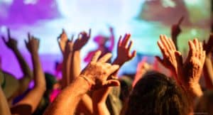 group of people waving their hands in the air