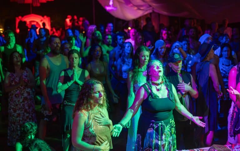 group of women at a movement event holding their hands open and looking to the sky