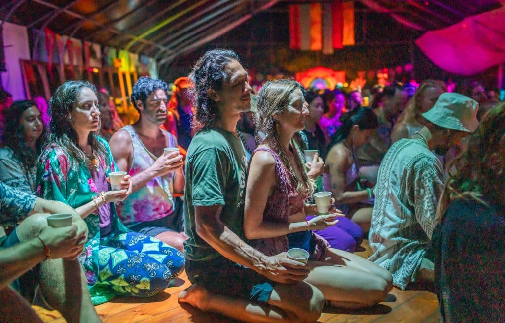 cacao ceremony during hoaloha event on big island in hawaii, men and women sitting together on floor holding cacao in cups