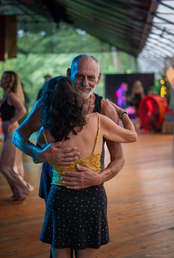 and older man and younger woman hugging at a movement event