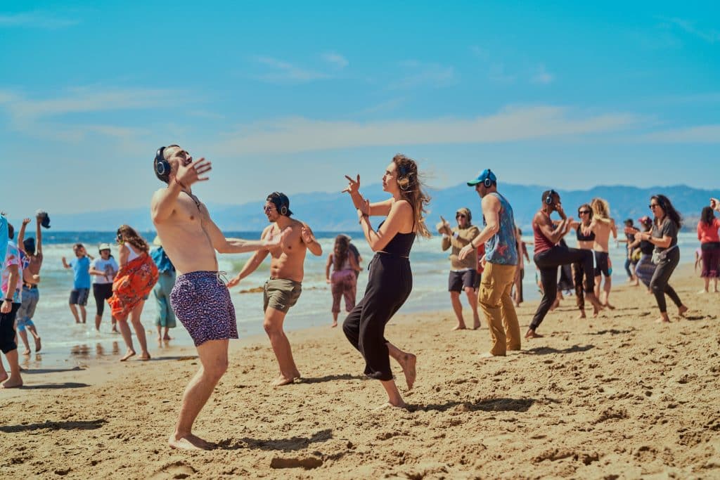 ecstatic dance la event on the beach, group of people dancing on beach
